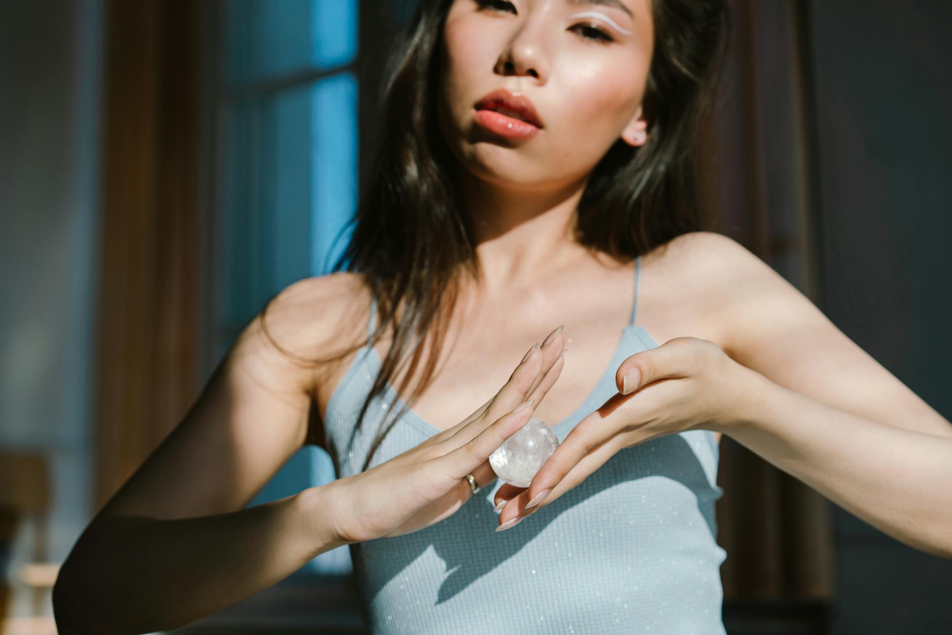 A woman holding a small crystal ball between her hands