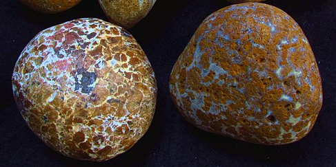 Two yellow jasper stones over a black background.